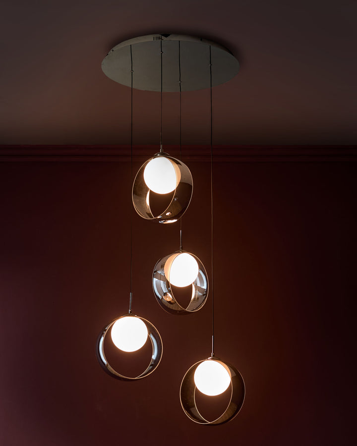 Chloe 4-pendant light with spherical chrome glass shades and white globes suspended from silver ceiling plate.