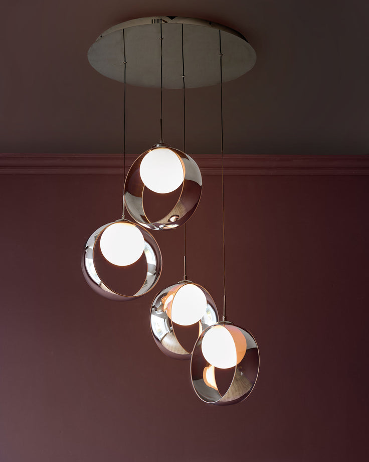 Chloe 4-pendant light with chrome finish, featuring four spherical glass shades with cutout designs, suspended from a circular ceiling plate.