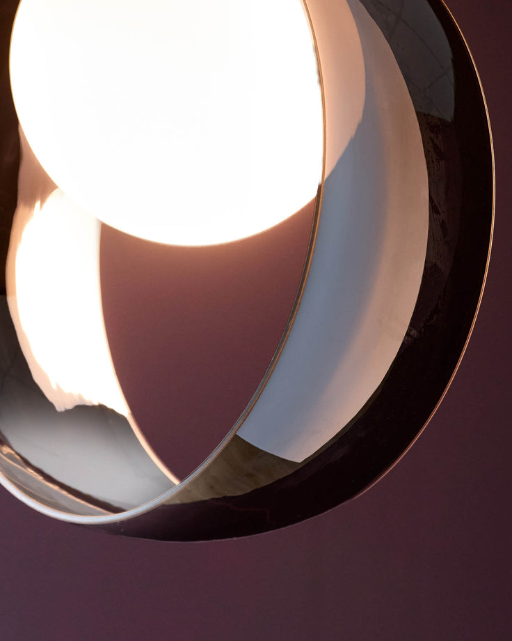 Chloe single pendant light with frosted white glass globe and polished chrome finish, photographed against purple background.