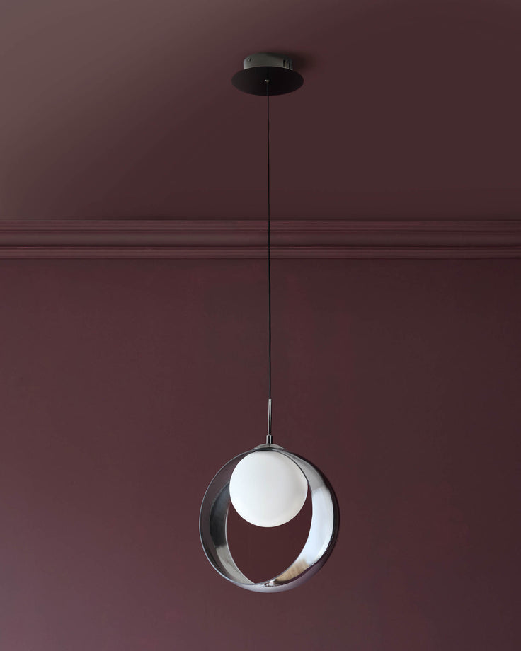 Chloe single pendant light with spherical glass shade in silver chrome finish, suspended from black cord against mauve wall.