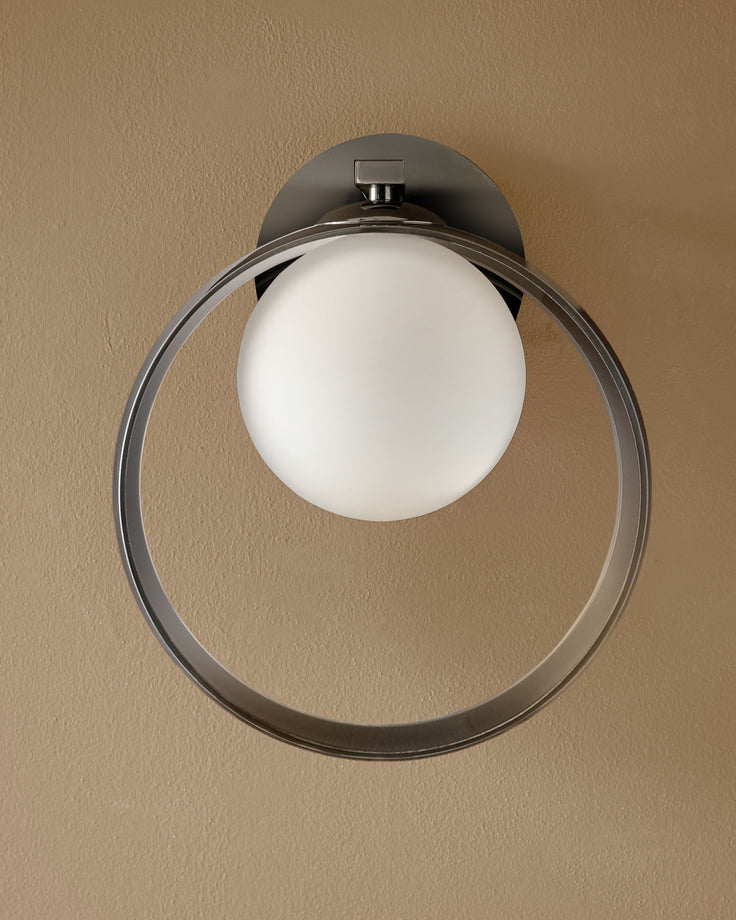 Chloe wall light with chrome finish, featuring a white frosted glass sphere suspended within a circular metal frame.