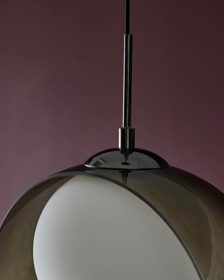 Chloe 4 pendant light with green glass shade and chrome metal fixture, photographed against mauve background.