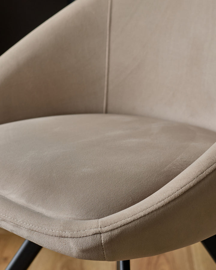 Cleo Velvet Swivel Chair in Champagne - close-up of curved seat and backrest showing soft velvet upholstery and stitched details.
