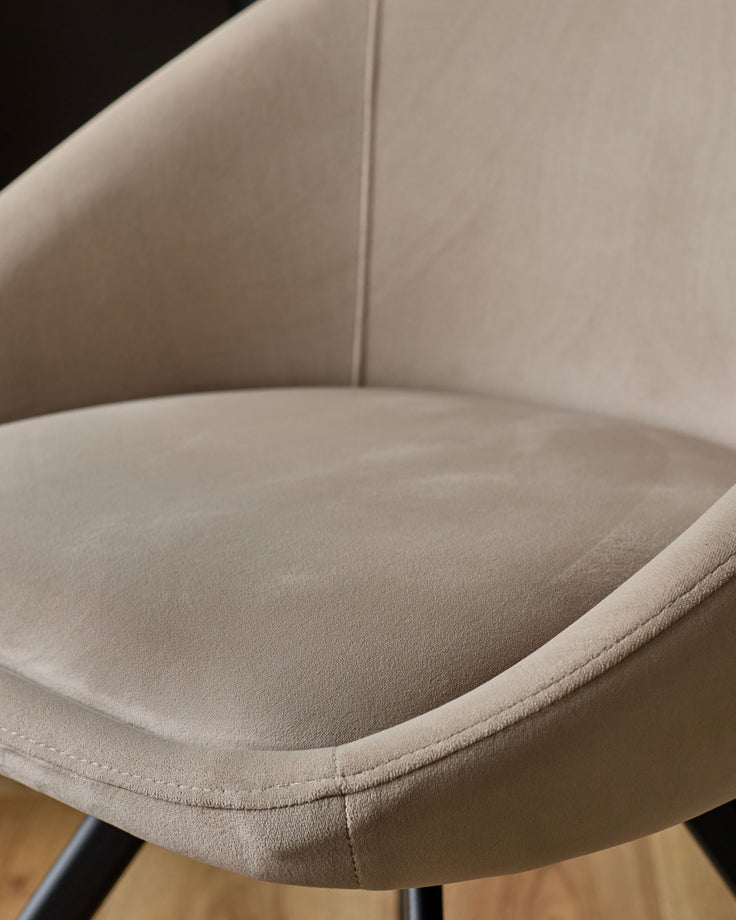 Cleo Velvet Swivel Chair in Champagne - close-up of curved seat and backrest showing soft velvet upholstery and stitched details.