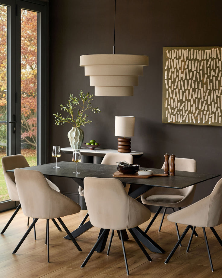 Madison round pendant light in natural linen, shown hanging above a dining table in a modern room setting.