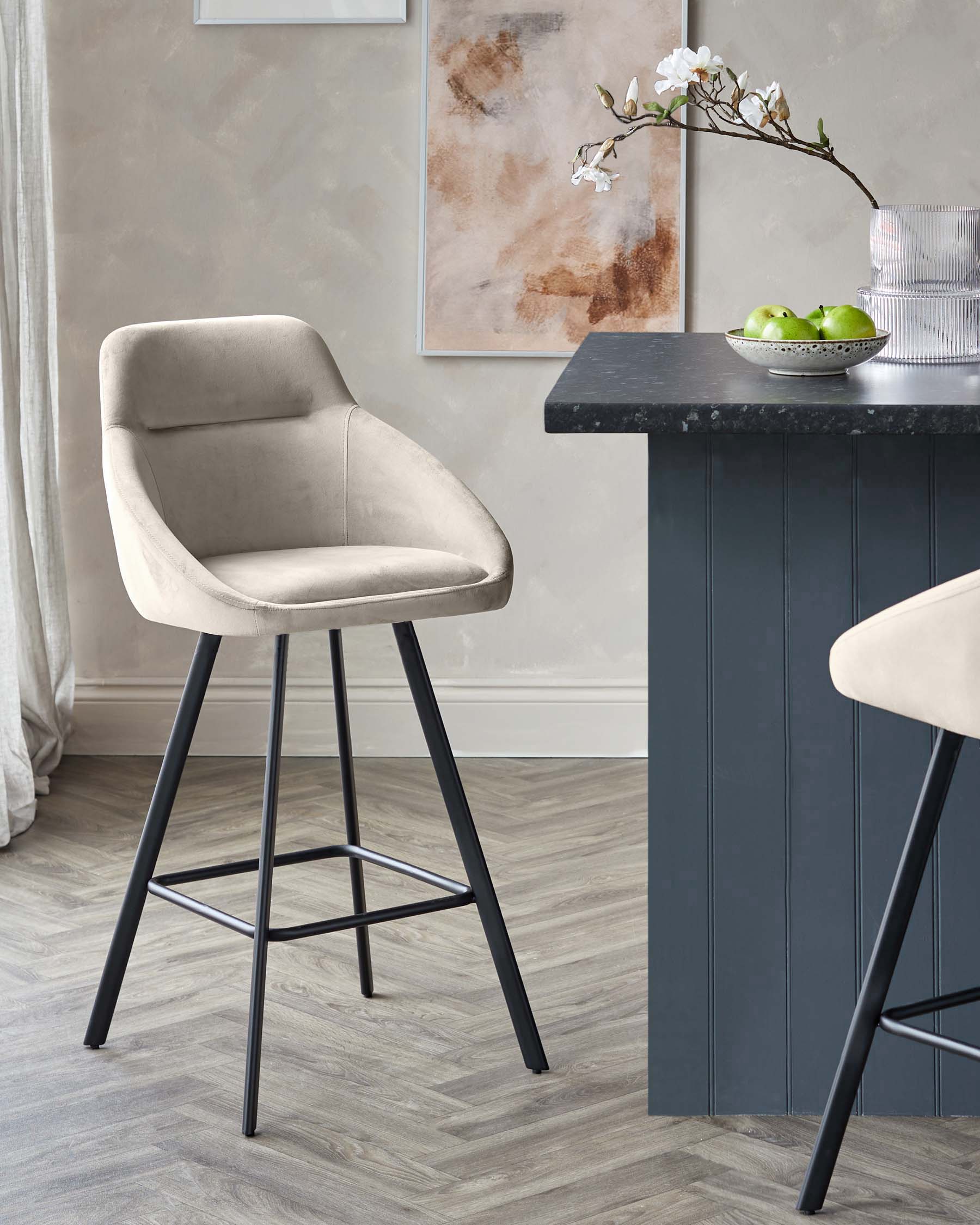 Stylish grey velvet bar stools with black metal legs, perfect for a modern kitchen or bar area.