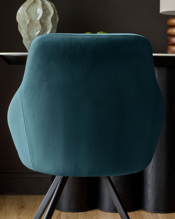 Cleo Velvet Swivel Chair in dark teal, shown from behind, displaying curved backrest and black swivel base.