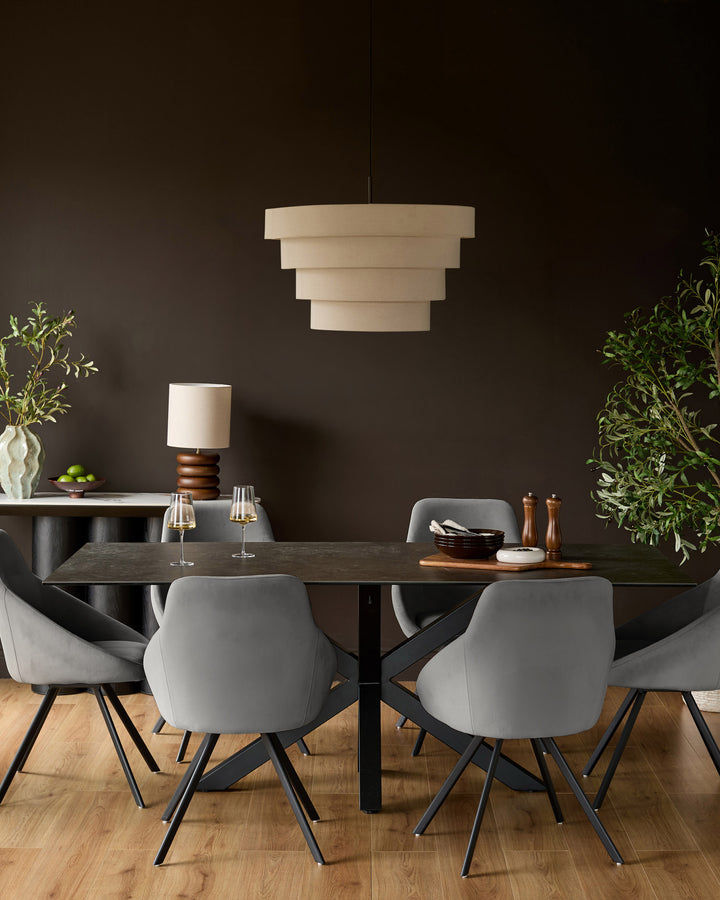 Cleo Velvet Swivel Chair in dark grey, shown in a modern dining room setting at a dark wood table.