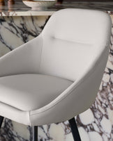 Cleo swivel bar stool in light grey faux leather, showing curved backrest and seat detail from side angle.