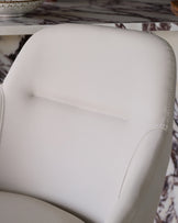 Cleo swivel bar stool in light grey faux leather, close-up of padded backrest with stitching detail.