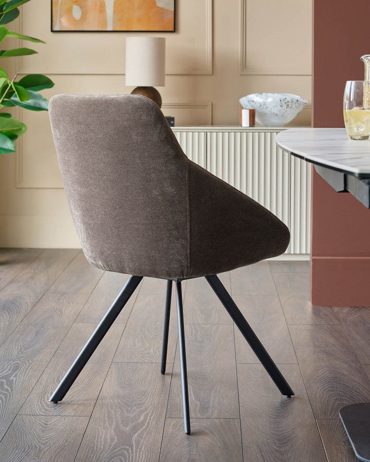 A contemporary dining chair with brown fabric upholstery and black metal legs, positioned in a stylish dining area.