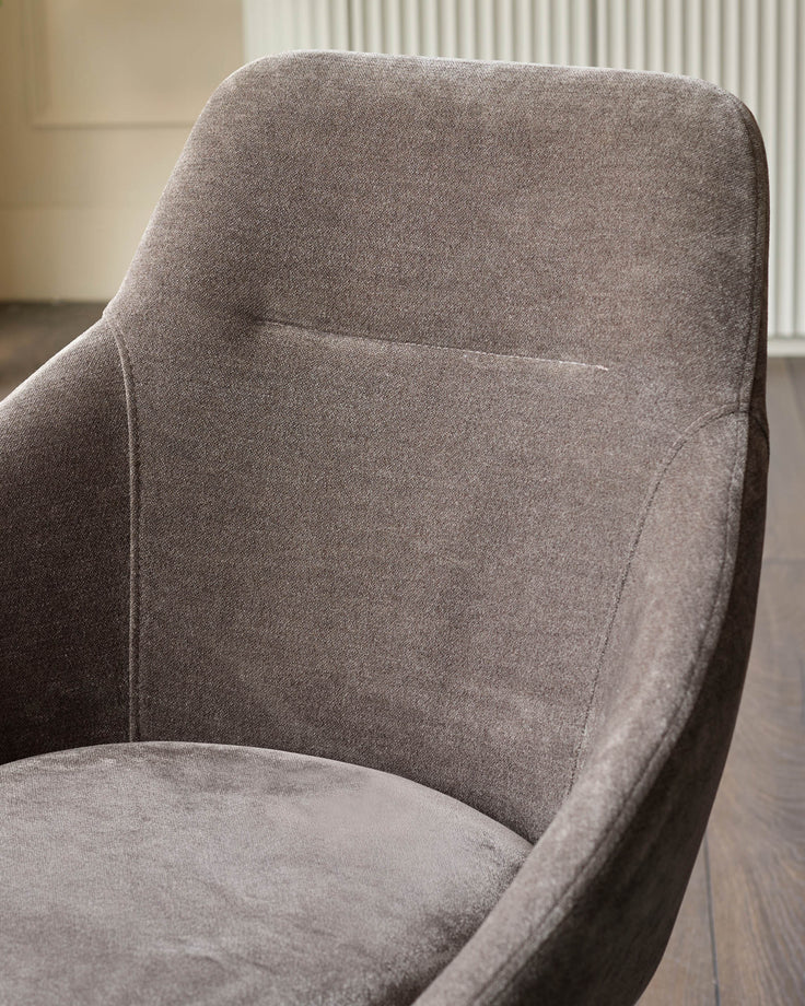 Close-up of an upholstered armchair in a textured, neutral fabric. Modern and stylish seating for any room.