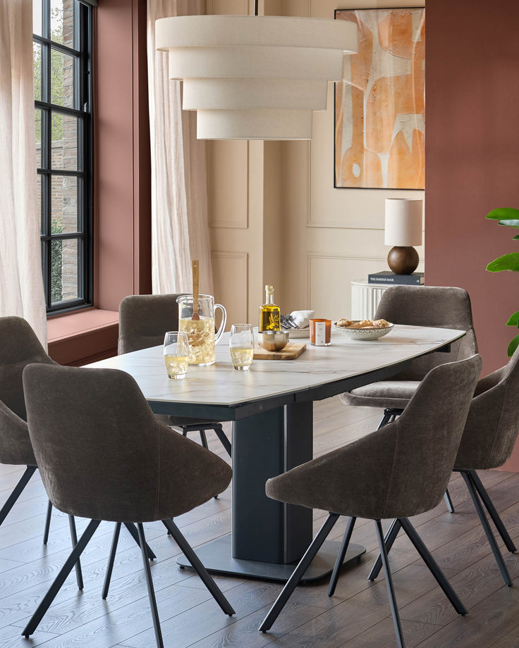 A dining set with a white marble effect table and six brown fabric chairs with black, tripod legs. A stylish, modern dining room setting.