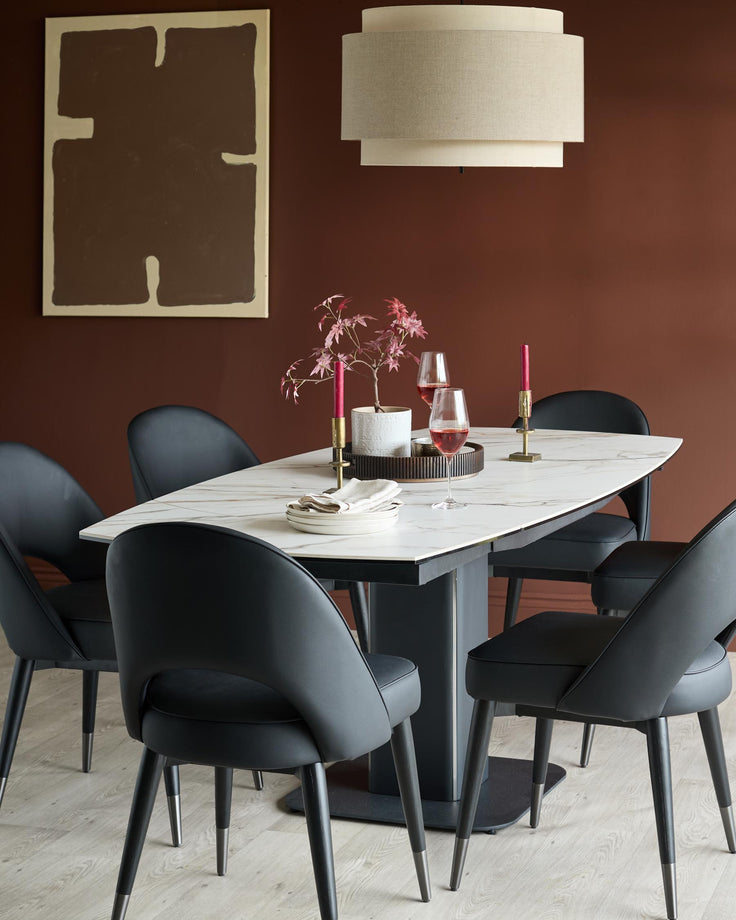 A modern dining set featuring a marble-look table, black leather chairs, and statement pendant light, creating a stylish dining space.