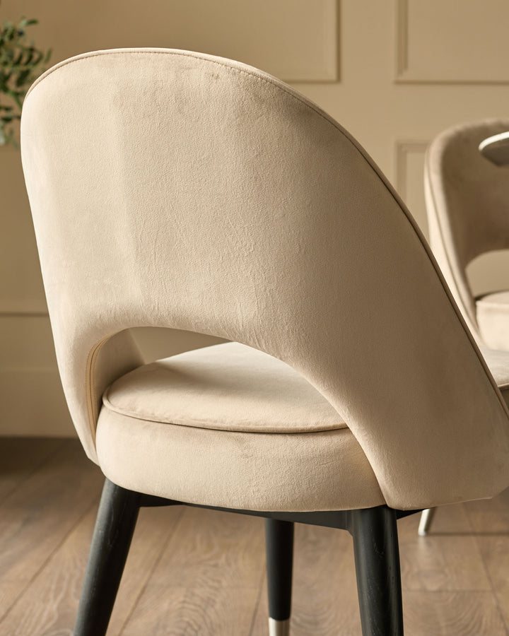 Clover Velvet Dining Chair in champagne, side view showing curved backrest and black legs with stainless steel caps.