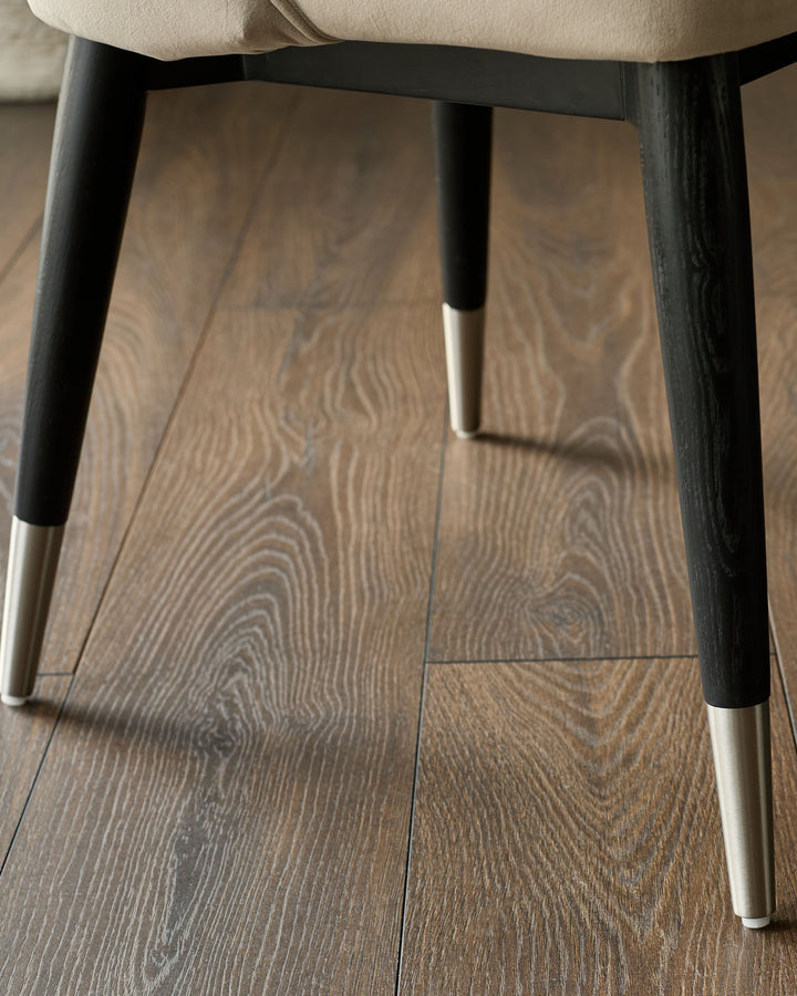 Clover Velvet Dining Chair in champagne with black wooden legs and stainless steel caps, viewed from underneath.