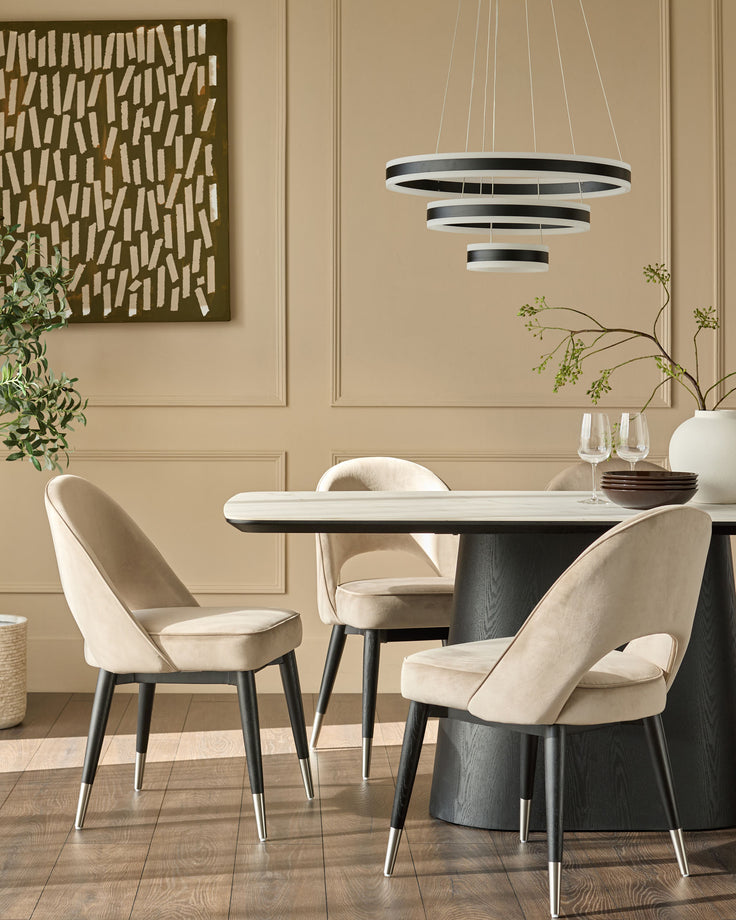 Champagne velvet dining chair with curved backrest and stainless steel leg caps, shown in room setting.