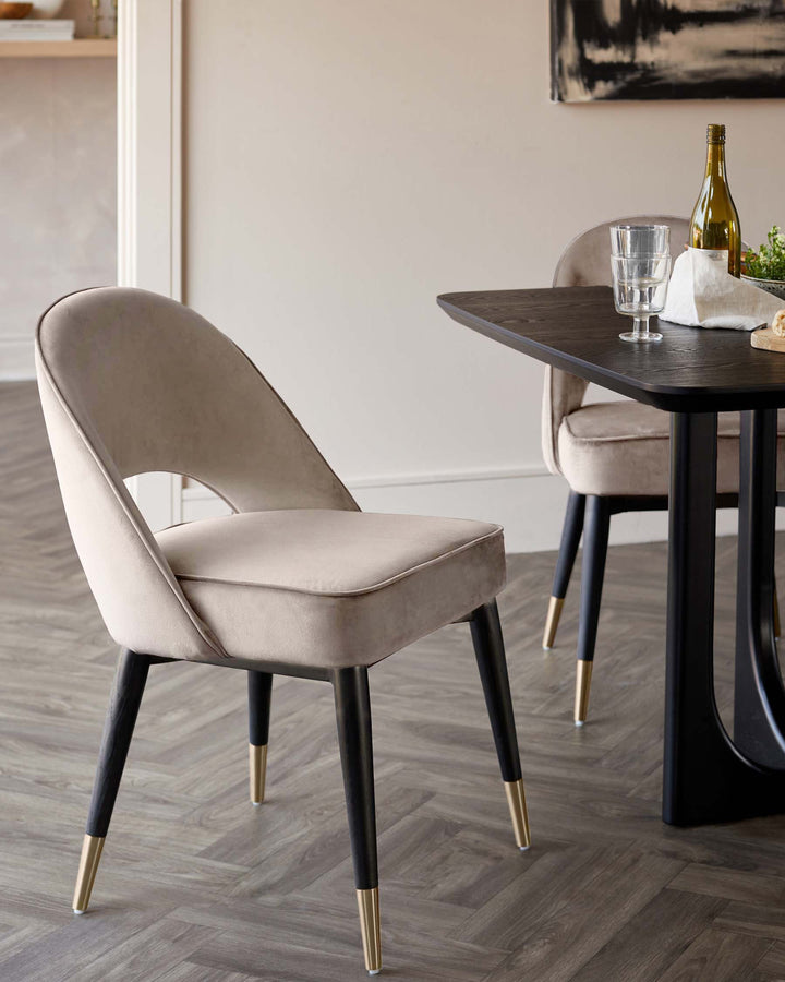 Stylish dining room with a dark wood table and two upholstered chairs with black and gold legs.