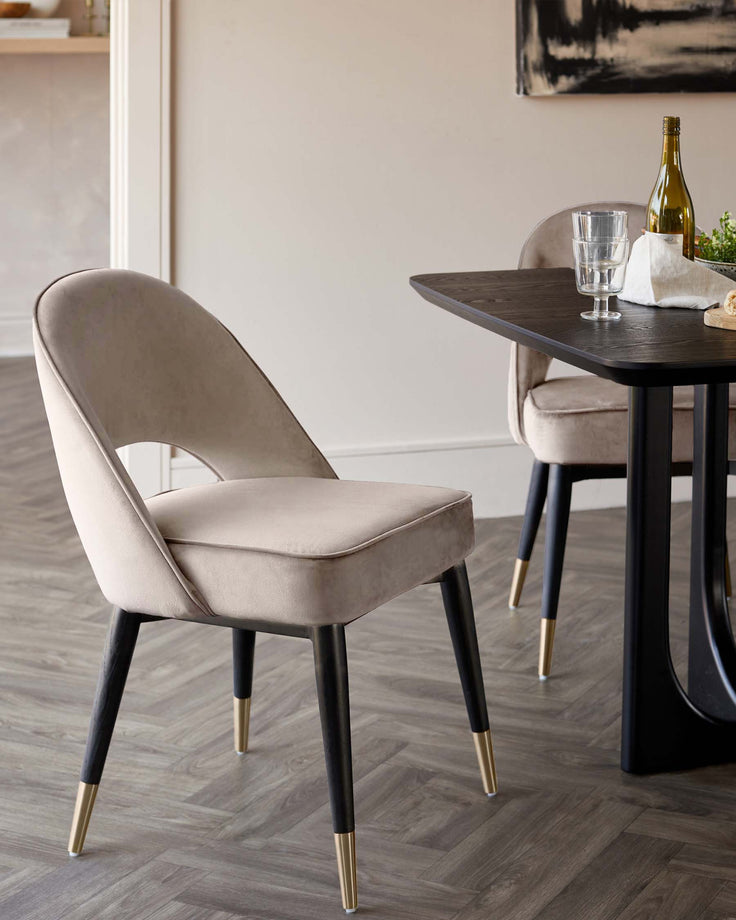 Stylish dining room with a dark wood table and two upholstered chairs with black and gold legs.