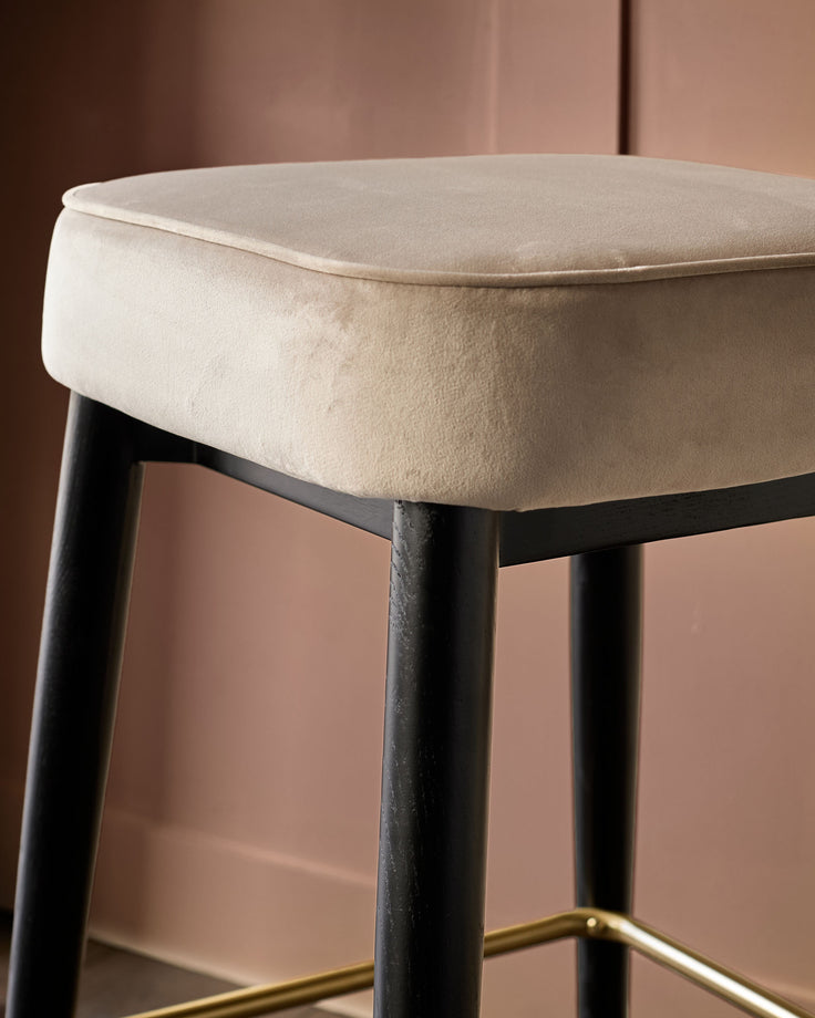 Clover Velvet Backless Bar Stool in Champagne with black legs and brass footrest detail.