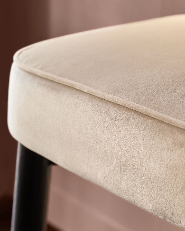 Clover Velvet Backless Bar Stool in Champagne, close-up detail of seat cushion and black leg base.
