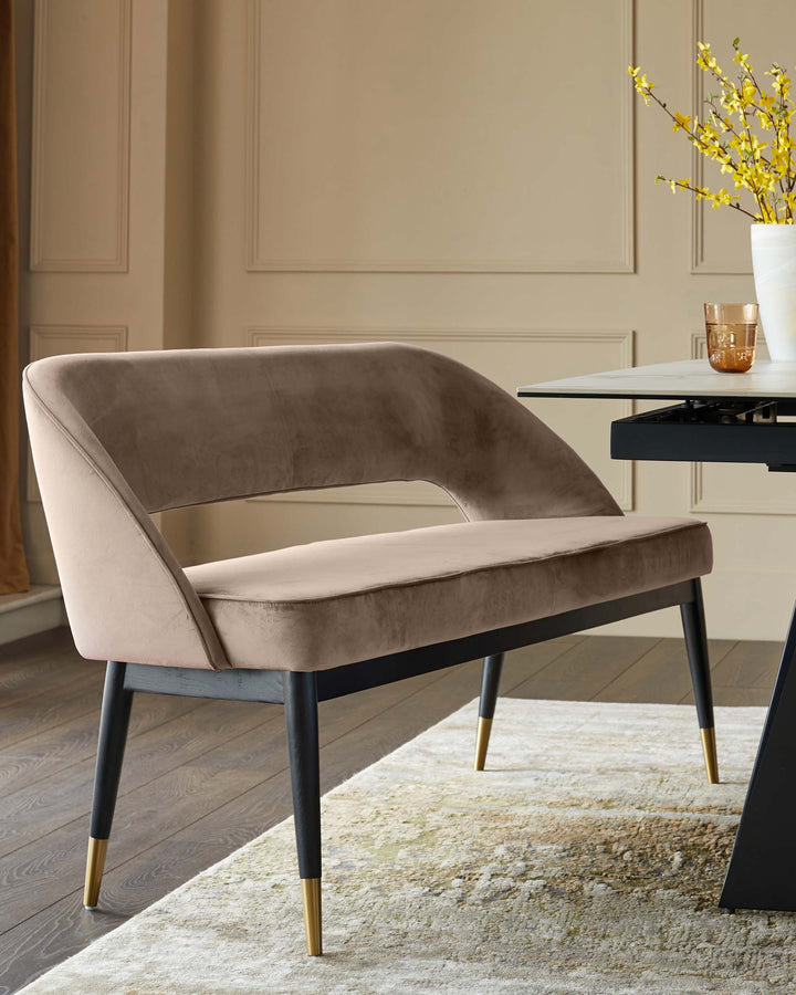 A luxurious, taupe velvet bench with sleek black legs and gold accents, adding a touch of glamour to any dining space.