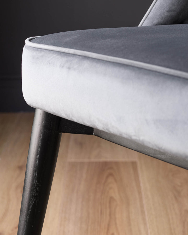Close-up of Clover dining chair showing white velvet seat, dark grey backrest, and dark wood leg with stainless steel cap.