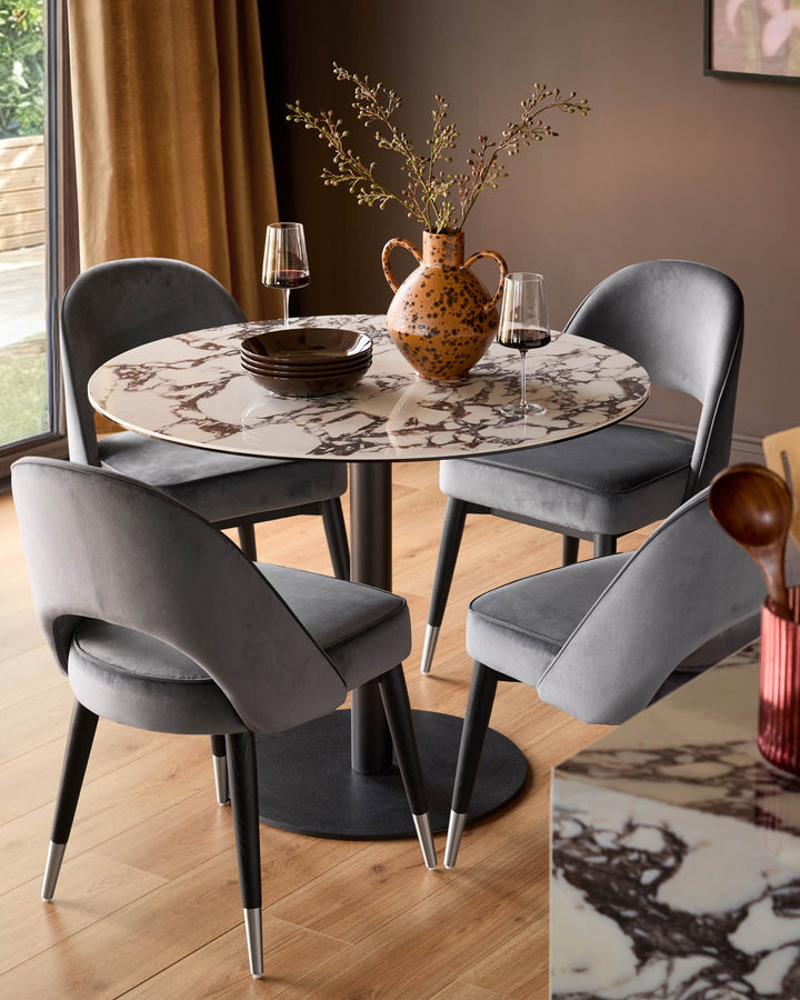 Clover velvet dining chair in dark grey with black legs and stainless steel caps, shown at round marble table.