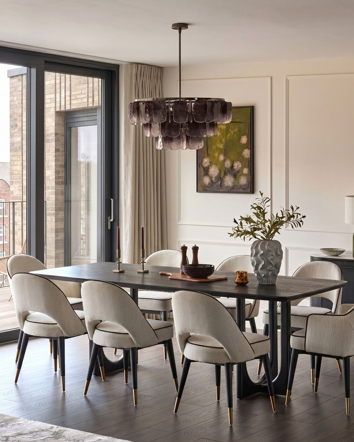Clover dining armchair in ivory fabric, shown in modern dining room setting around black table.