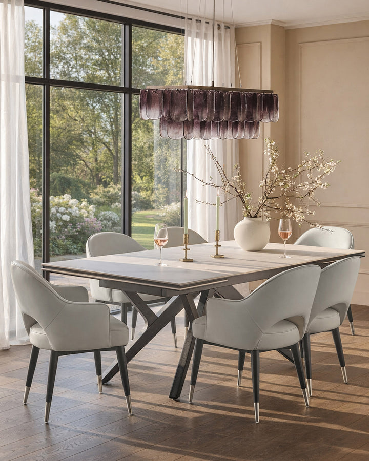 Clover dining armchair in light grey faux leather with black legs and metal feet, shown in dining room setting.