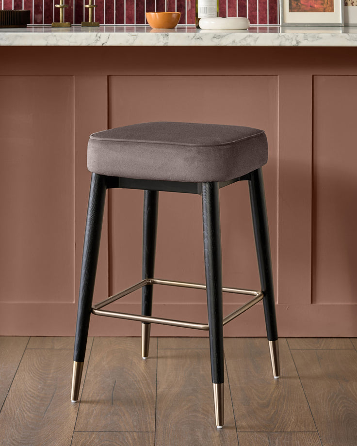 Clover mocha velvet backless bar stool with black tapered legs and brass footrest, front view.