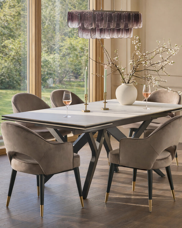 Clover mocha velvet dining armchair with black wooden legs and gold metal accents, shown in dining setting.