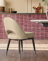 A stylish chair with a padded seat and back, complemented by sleek, dark legs with metallic tips.
