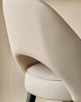 Close-up of a cream coloured chair with a leather-like texture, showcasing its design and quality.