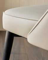 Close-up of a beige leather seat with dark wooden legs. Modern furniture, ideal for a stylish home.