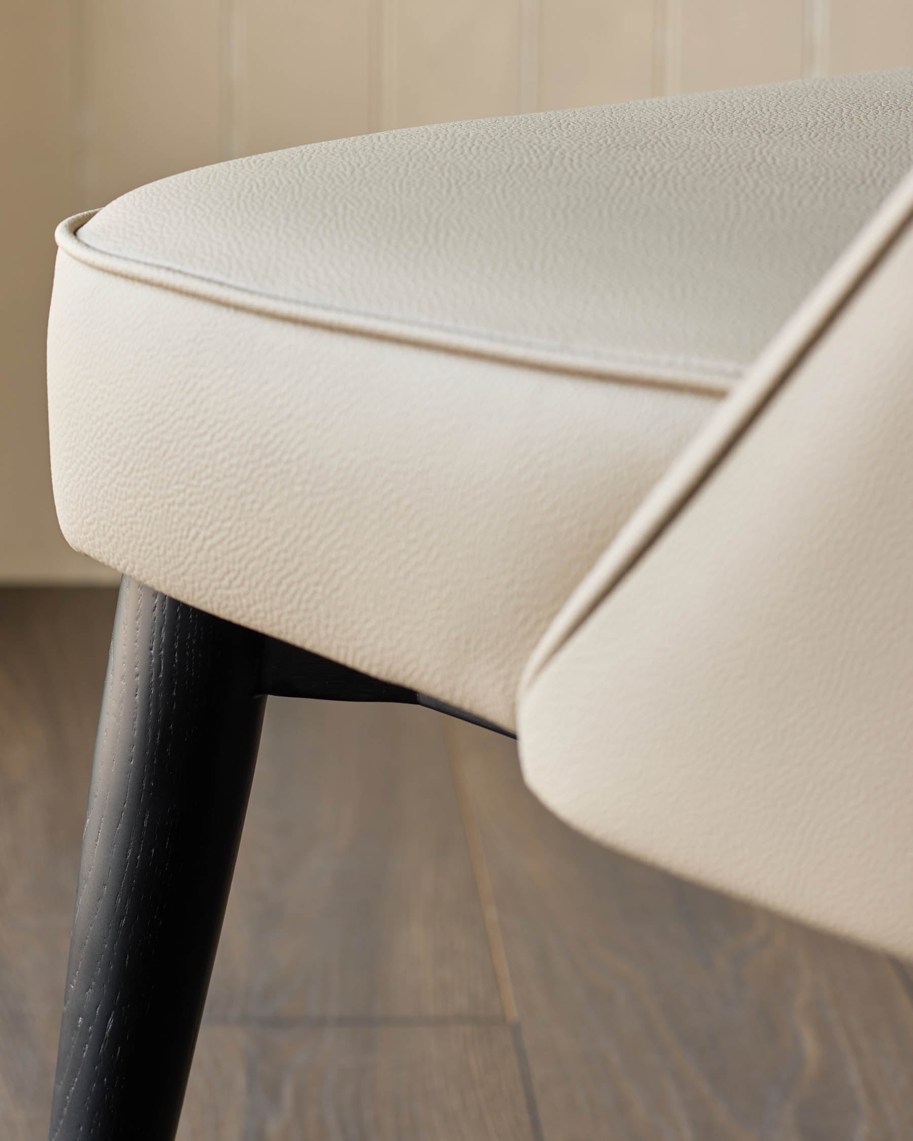 Close-up of a beige leather seat with dark wooden legs. Modern furniture, ideal for a stylish home.