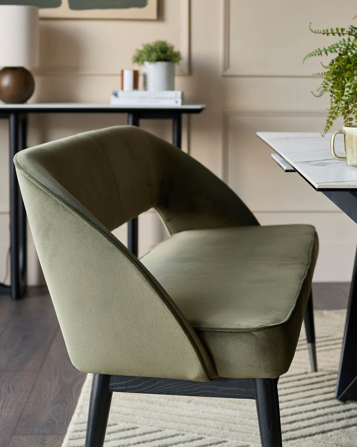 Olive green velvet dining chair with curved back and black legs. Contemporary and stylish seating for your dining room.