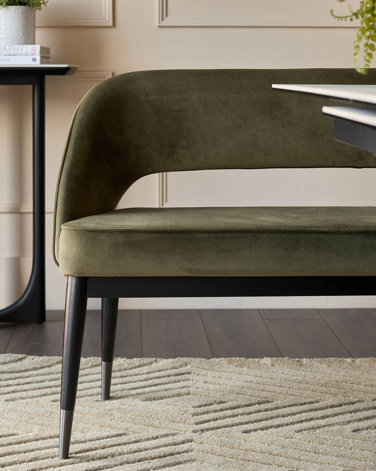 Olive green bench seat with wooden legs and geometric patterned rug. Perfect for the dining room.