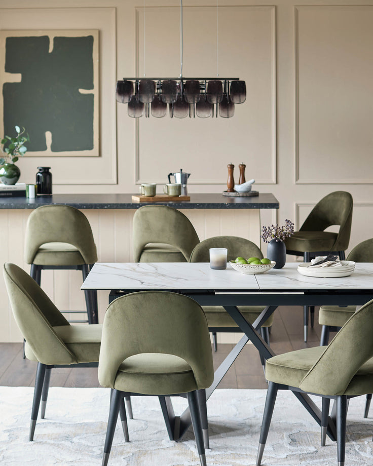 Dining set with a marble-look table surrounded by six stylish olive green velvet chairs and bar stools.