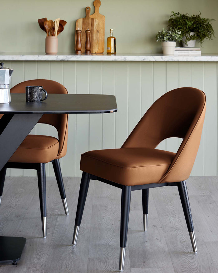 A sleek black table accompanied by stylish brown upholstered chairs with metal legs, set against a soft green backdrop.