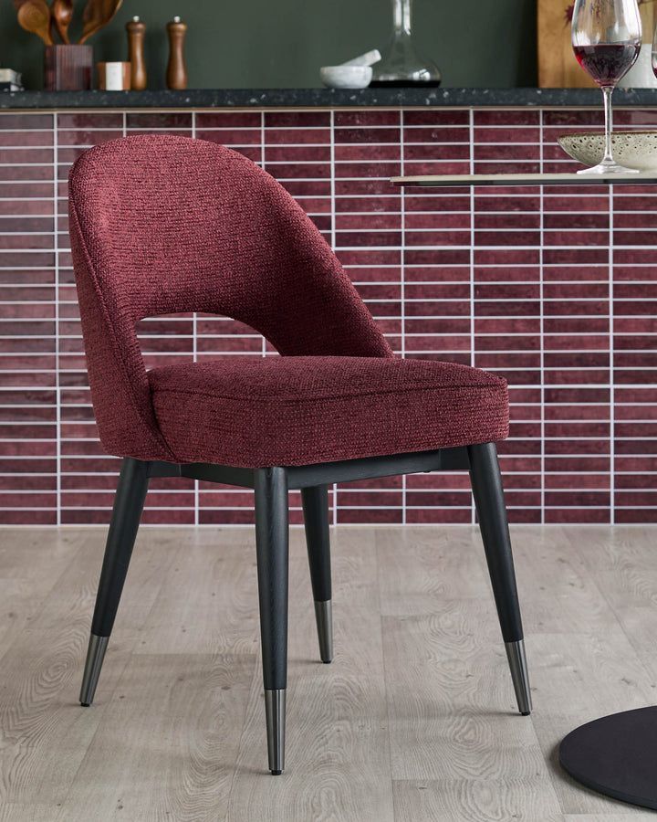 A red fabric dining chair with black legs, accessorised with chrome feet. A stylish addition to any dining space.