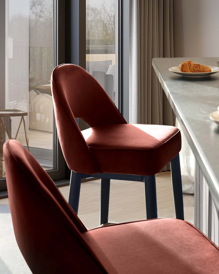 Two stylish chairs sit near a counter with a croissant, bringing modern design and comfort to your dining space.