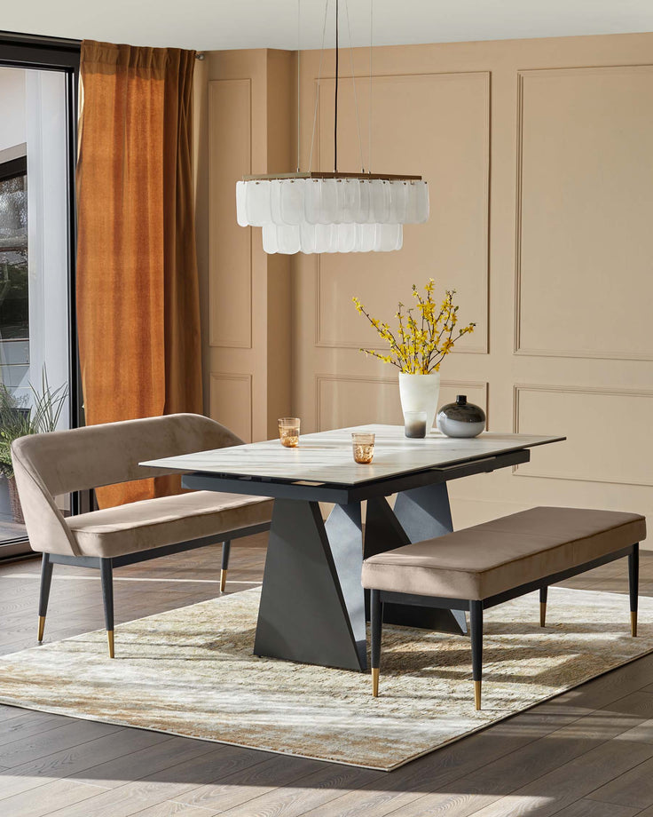 A dining table with marble top and bench seating underneath a modern chandelier, creating an elegant dining space.