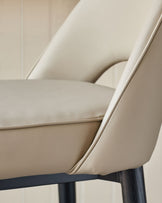 Close up of a stylish cream chair with black legs. Modern design for a dining or living area.