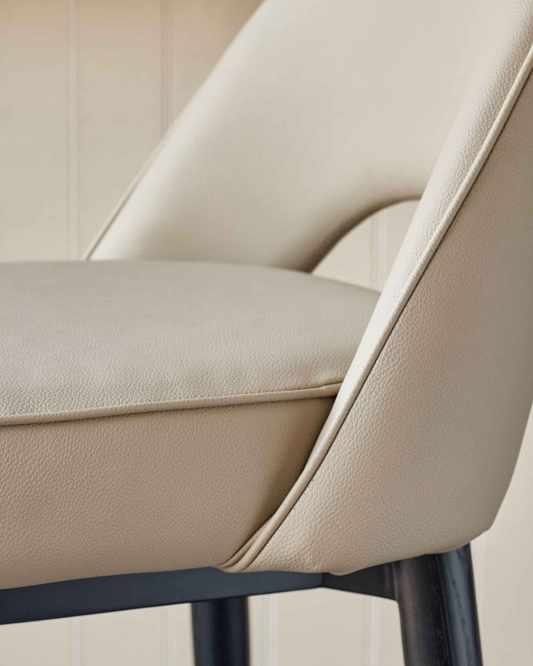 Close up of a stylish cream chair with black legs. Modern design for a dining or living area.