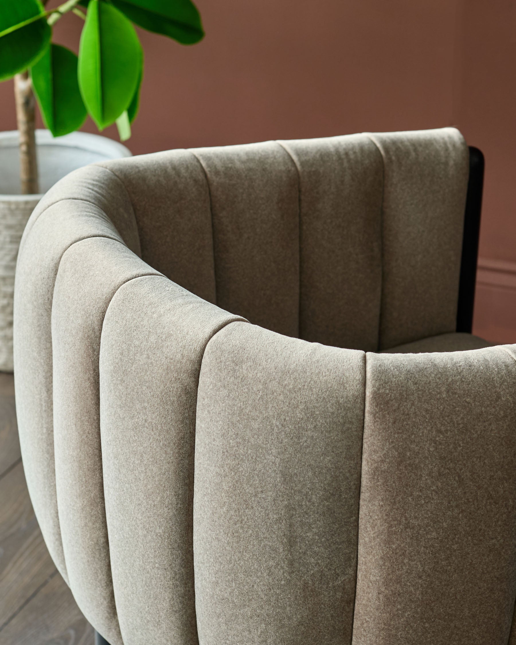 A luxurious, curved back chair upholstered in a textured, neutral fabric. Ideal for adding elegance to any room.