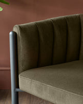 Close up of a green chair with a metal frame. The chair has a padded seat and back, and is upholstered in a soft fabric.