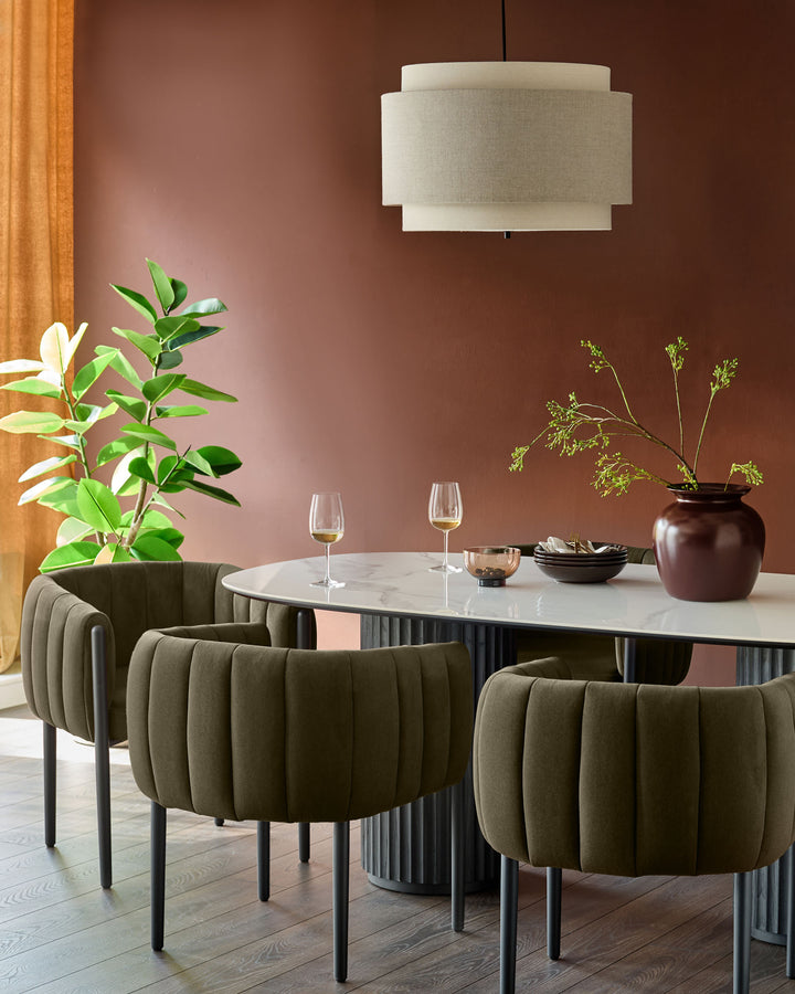 An elegant dining set featuring a marble table, plush olive chairs, and a stylish, tiered lampshade. Perfect for modern homes.