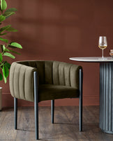 A luxurious velvet armchair sits beside a round marble table, creating a chic and inviting space.