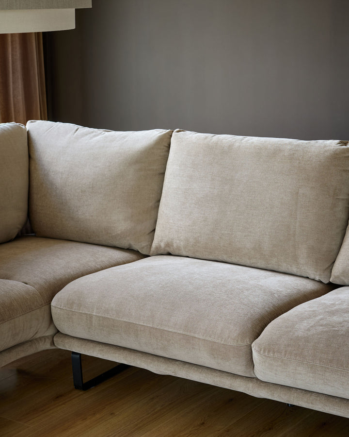 Colette left-hand corner chaise sofa in mink fabric, featuring plush cushioning and modern metal legs, photographed from a side angle.
